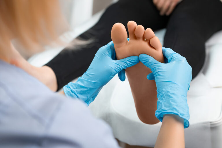 Foot Doctor holding a patient's foot with blue gloves - Find a Podiatrist in Great Neck